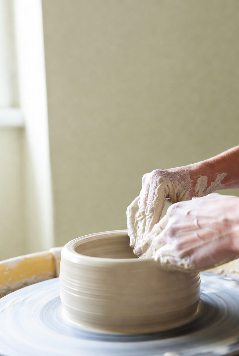 Potter shaping clay at the wheel